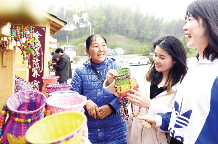 4月14日，游客在大湾村流动售货亭前选购旅游工艺品
